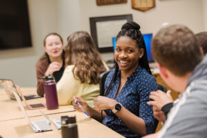 A diverse group of students studying together in a computer lab.